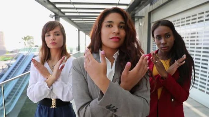 三名商界女性交叉双臂，发起“打破偏见”运动，支持国际妇女节。