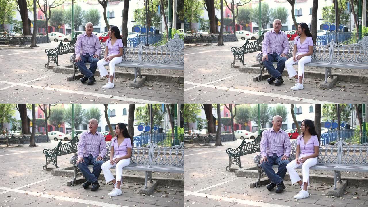 祖父和孙女在公园里聊天。