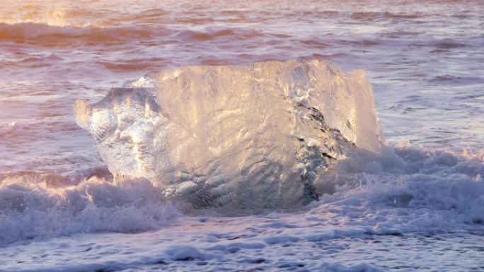 冰岛的钻石海滩，冰山在日落时照耀着黑色的火山沙，清澈的冰被海浪撞击，以8k分辨率拍摄4320p