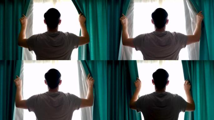 男子站在窗前，打开绿松石窗帘后视。