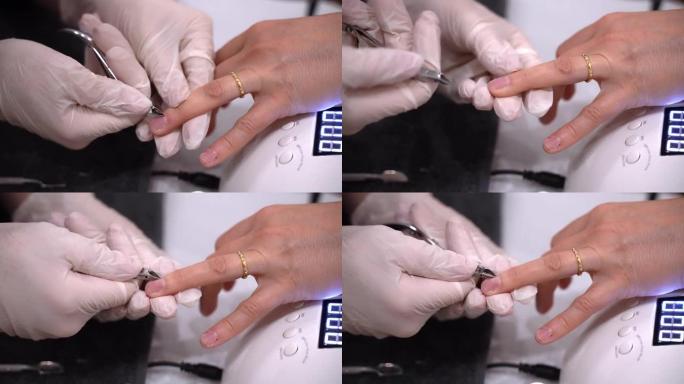 专业美甲师在一次性手套中使用金属钳去除指甲上的角质层，掌握准备女性指甲的凝胶指甲油，并在紫外线发光二
