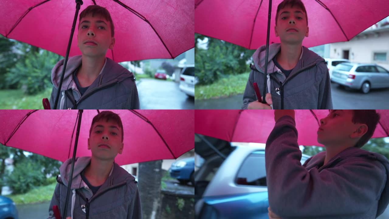 一个小男孩在下雨时拿着红伞走在外面。下雨天，青春期的孩子在户外散步