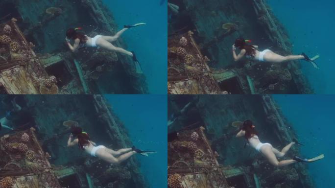 妇女在马尔代夫清澈的水中在沉船上游泳和浮潜