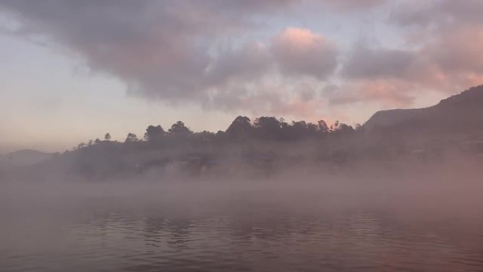 美丽的山湖覆盖，水面上有早晨浓雾，宁静的日出景观