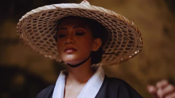 一个穿着和服的女人触摸她的竹帽的特写镜头