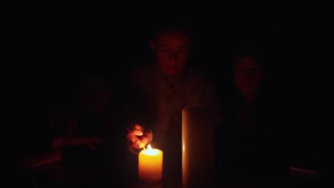 停电期间，家人坐在蜡烛旁。乌克兰战争