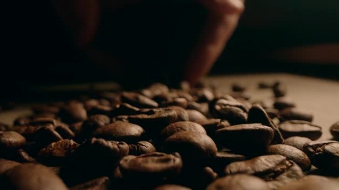 手掌拿着咖啡豆的宏观镜头，把它放进去。慢动作摄像机移动。