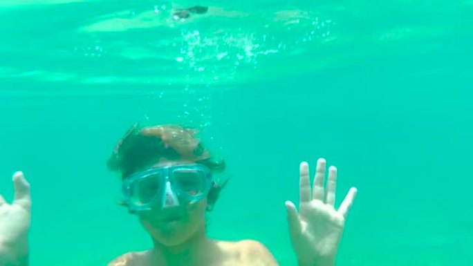 这个男孩在印度洋水下潜水游泳。儿童在温水中嬉戏