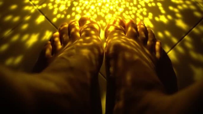 一个男人在美丽的灯光下玩脚趾
