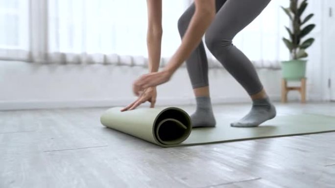 白人妇女铺了一张垫子，为瑜伽锻炼做准备。
