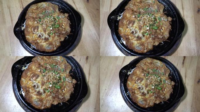 在热的黑色平底锅上，用豆芽煎牡蛎煎蛋卷。在热锅中，此菜单已准备好供应和消费。