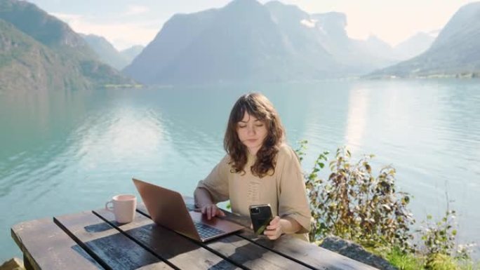女人在蓝湖的背景下使用笔记本电脑