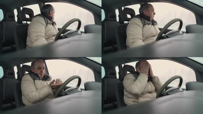 疲惫的男司机在冬天打开了汽车的挡风玻璃。