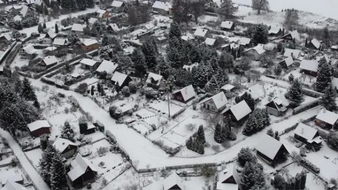 鸟瞰宁静的小镇，在深沉新鲜的雪下，冬天初。大雪期间的乡村屋顶。郊区居民区冬日。欧洲波兰。