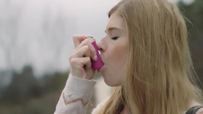 一名妇女在山区旅行中使用哮喘吸入器进行发作。