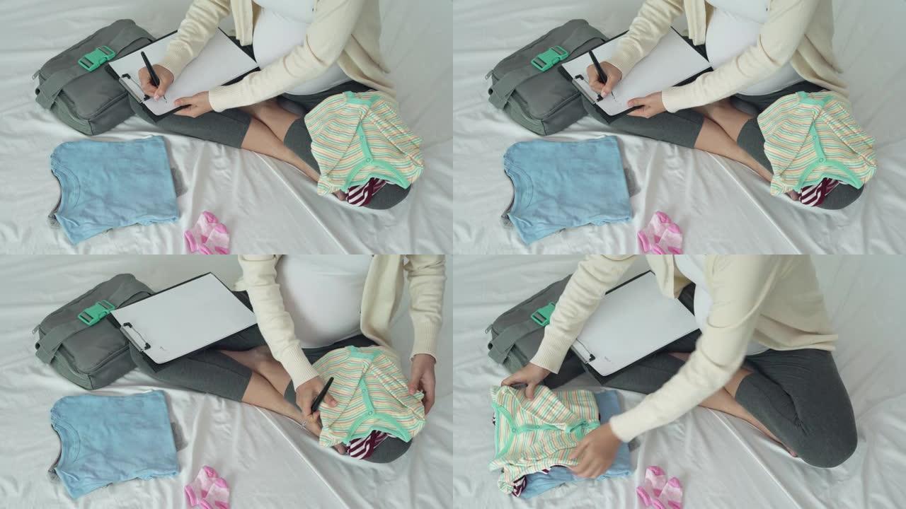 一名孕妇在纸上写下新生儿必要的复查。母亲正在折叠并保留衣服，为即将到来的婴儿做准备。为新生概念感到高