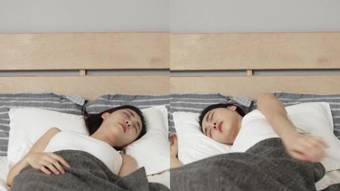 垂直屏幕: 失眠的亚洲年轻韩国妇女在家里卧室里不舒服的床褥上翻来覆去。