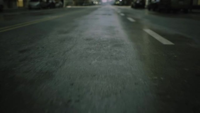 街道路上雨后早上湿沥青的特写电影视点拍摄。汽车剪影在背景中聚焦
