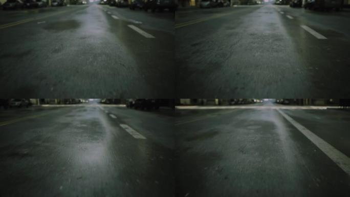 街道路上雨后早上湿沥青的特写电影视点拍摄。汽车剪影在背景中聚焦