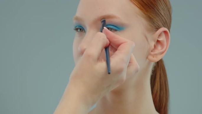 化妆师画了一个女孩的眉毛。