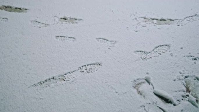 冬季暴风雪期间，靴子脚印在新鲜的雪中
