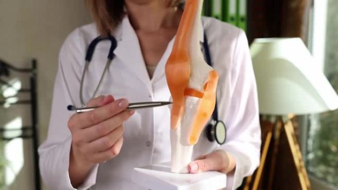 医生在人体膝关节特写4k电影慢动作的人工模型上展示韧带和肌肉