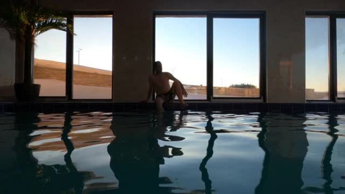 男子在寒冷的冬日在室内游泳池游泳