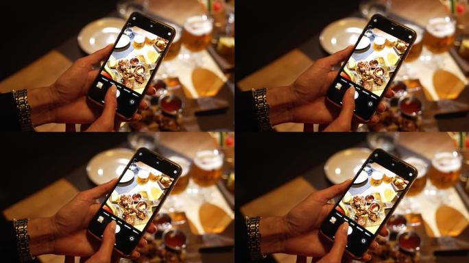 女孩用手机拍下了在一家餐馆里供应给她的美味佳肴的照片