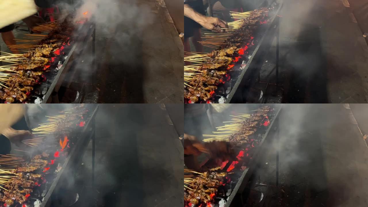 在炭炉上用竹棍串起来的鸡肉。
