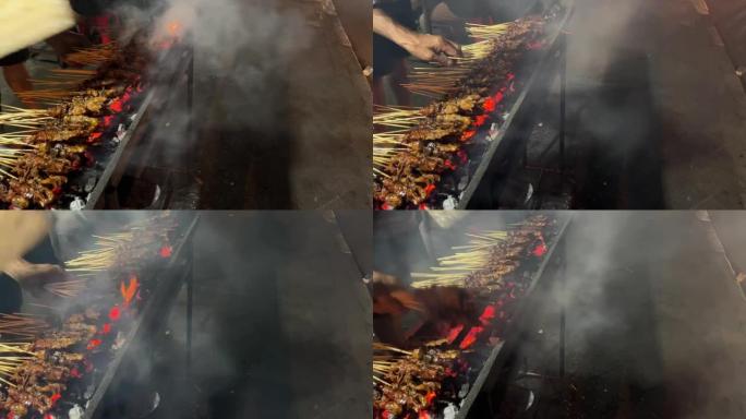 在炭炉上用竹棍串起来的鸡肉。