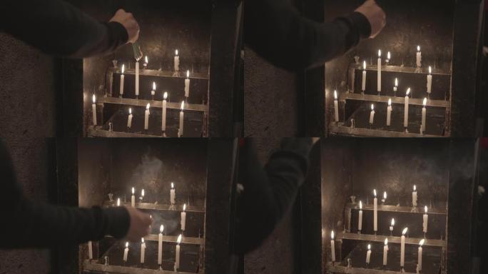 手在旧蜡烛点燃的祭坛上烧香