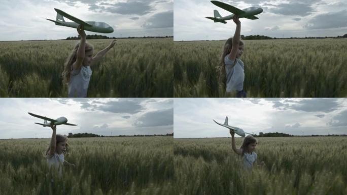 可爱的小女孩手里拿着飞机玩具在麦田里奔跑，相机跟随