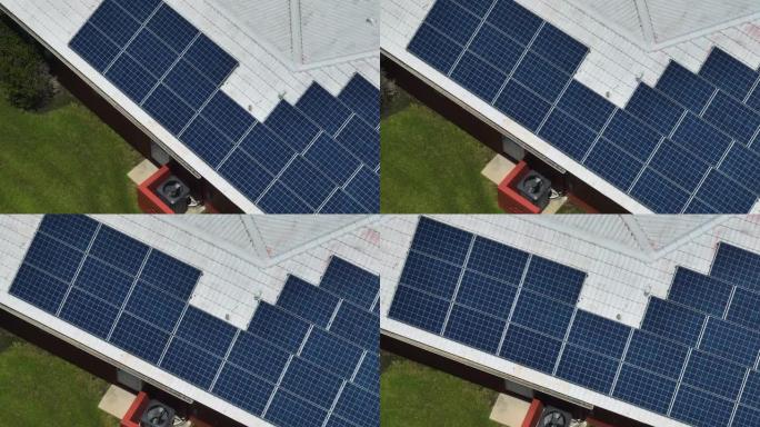 带有蓝色太阳能光伏板的普通美国家庭屋顶的鸟瞰图，用于产生清洁的生态电能。零排放概念的可再生电力