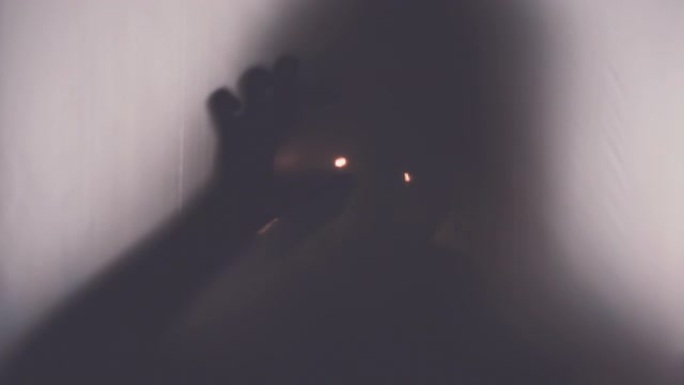 一个男人的剪影在透明的窗帘后面，发光的眼睛，将他的手拉进相机。超凡脱俗的生物、恶魔、超自然、鬼魂的概