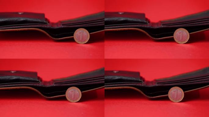 红色背景上的保加利亚列夫硬币。背景中模糊的空钱包。通货膨胀，钱荒。