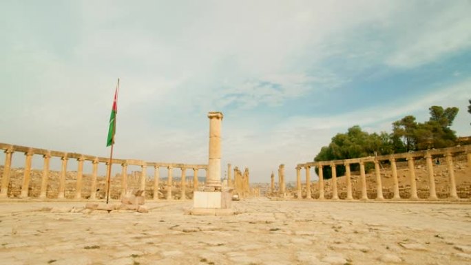 在带有约旦国旗的椭圆形广场上放置的离子柱的风景，杰拉什。