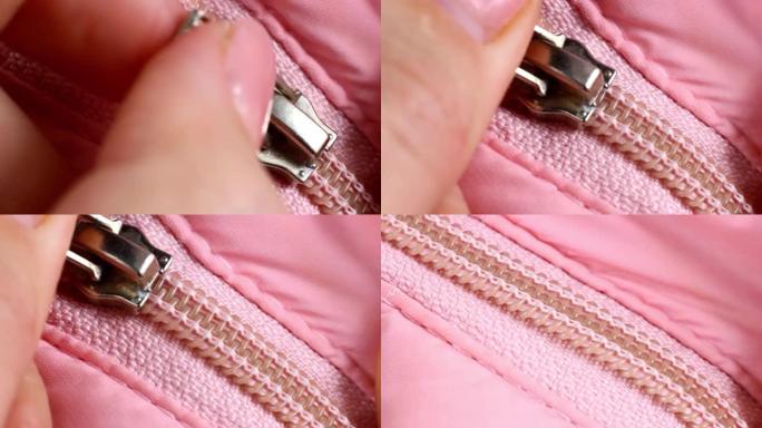 女人双手拉链粉色塑料拉链，金属细节特写