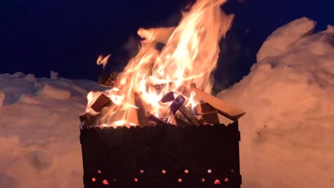 晚上，烤架上堆放的木柴燃烧得很好，明亮。