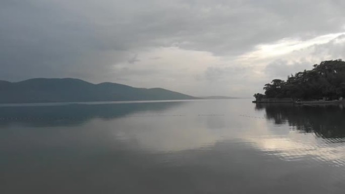 在茂密的树木和山脉环绕的湖泊周围进行空中缓慢运动