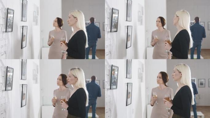 两个朋友在一个美术馆里，在一个当代艺术展览上。女人喝香槟讨论绘画