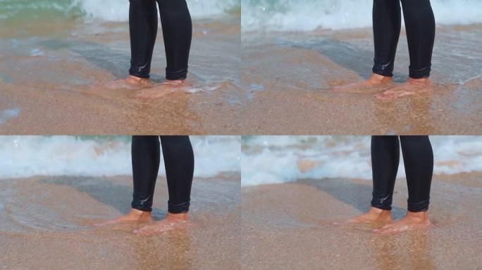 除了飞溅的波浪外，印度妇女在沙滩上的腿的特写镜头。年轻女性在海滩享受暑假