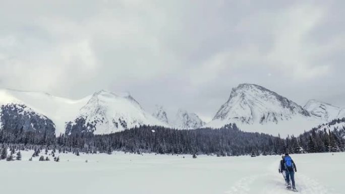 下雪季节的冬季徒步旅行。加拿大洛矶山卡纳纳斯基斯的全景景观在最冷的冬季圣诞节假期季节风景优美。人们在