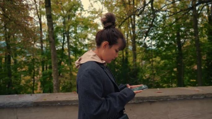 旅游妇女在走路时使用智能手机