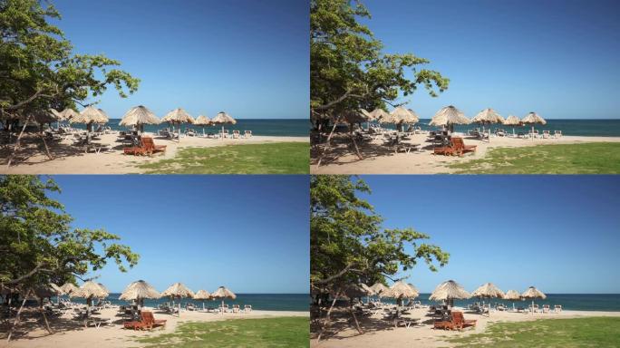 酒店海滩，一大早没人。海边的稻草伞和空的太阳躺椅