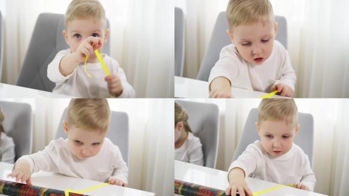 一个男孩解开一条黄色的礼品包装丝带。