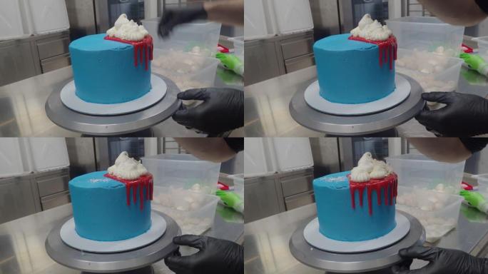 蛋糕糕点厨师设计师装饰一个蓝色蓝绿色磨砂糖霜蛋糕，用于进一步装饰，红色滴水加甘纳许和白色蛋白酥皮在4