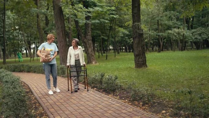 社会服务工作者探访残疾老年妇女，在公园散步