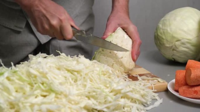 4k一位男厨师用刀将新鲜白菜切成细碎。酸菜的准备。