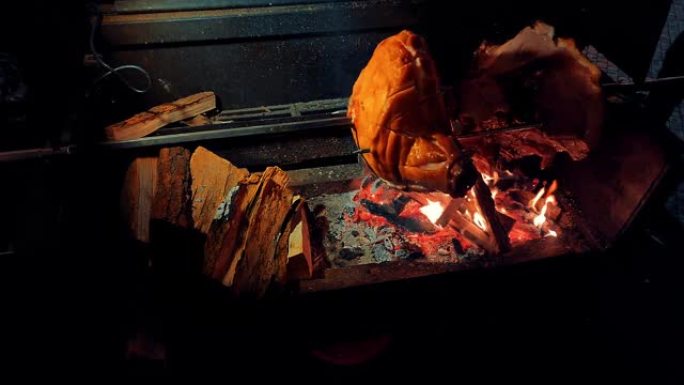 大块肉在火上烧烤烤猪腿烤肘子野外烧烤