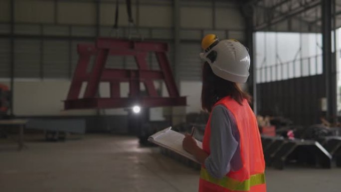 亚洲女性建筑工程师使用平板电脑，建筑概念在车间检查工作。